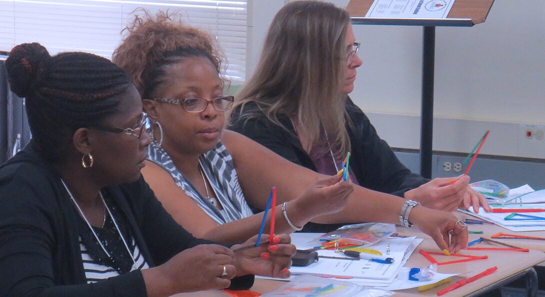 Three teachers engaged in a workshop